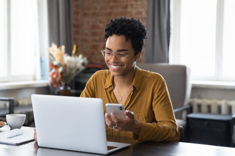 Woman working while holding phone - Telepsychiatry in Baytown, TX